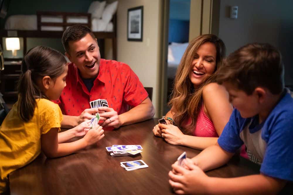 family playing cards in family suite at the Greystone Lodge
