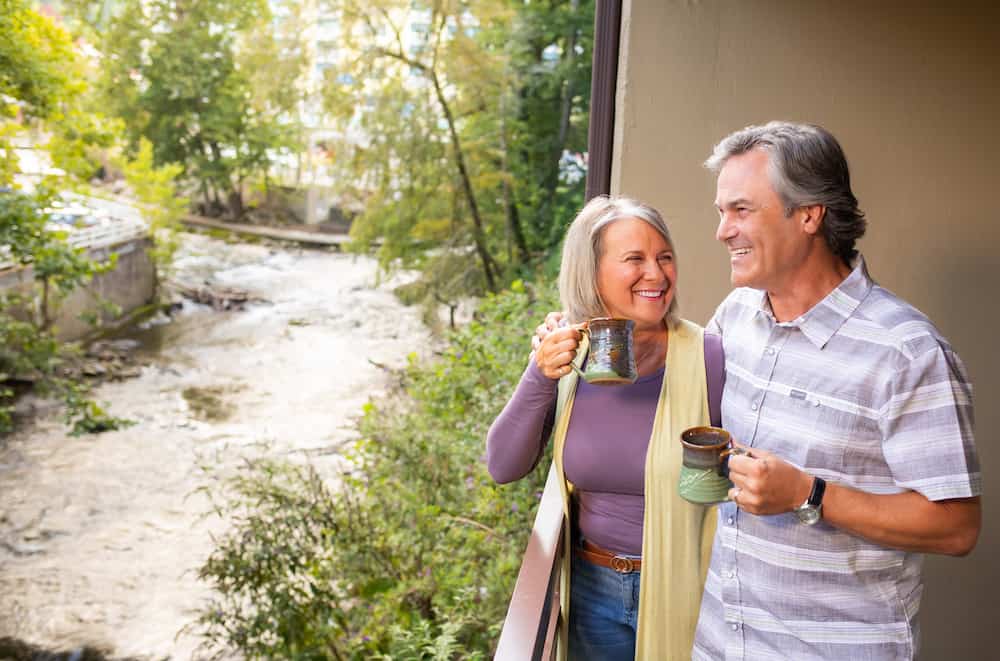 couple enjoying coffee on the balcony of greystone lodge